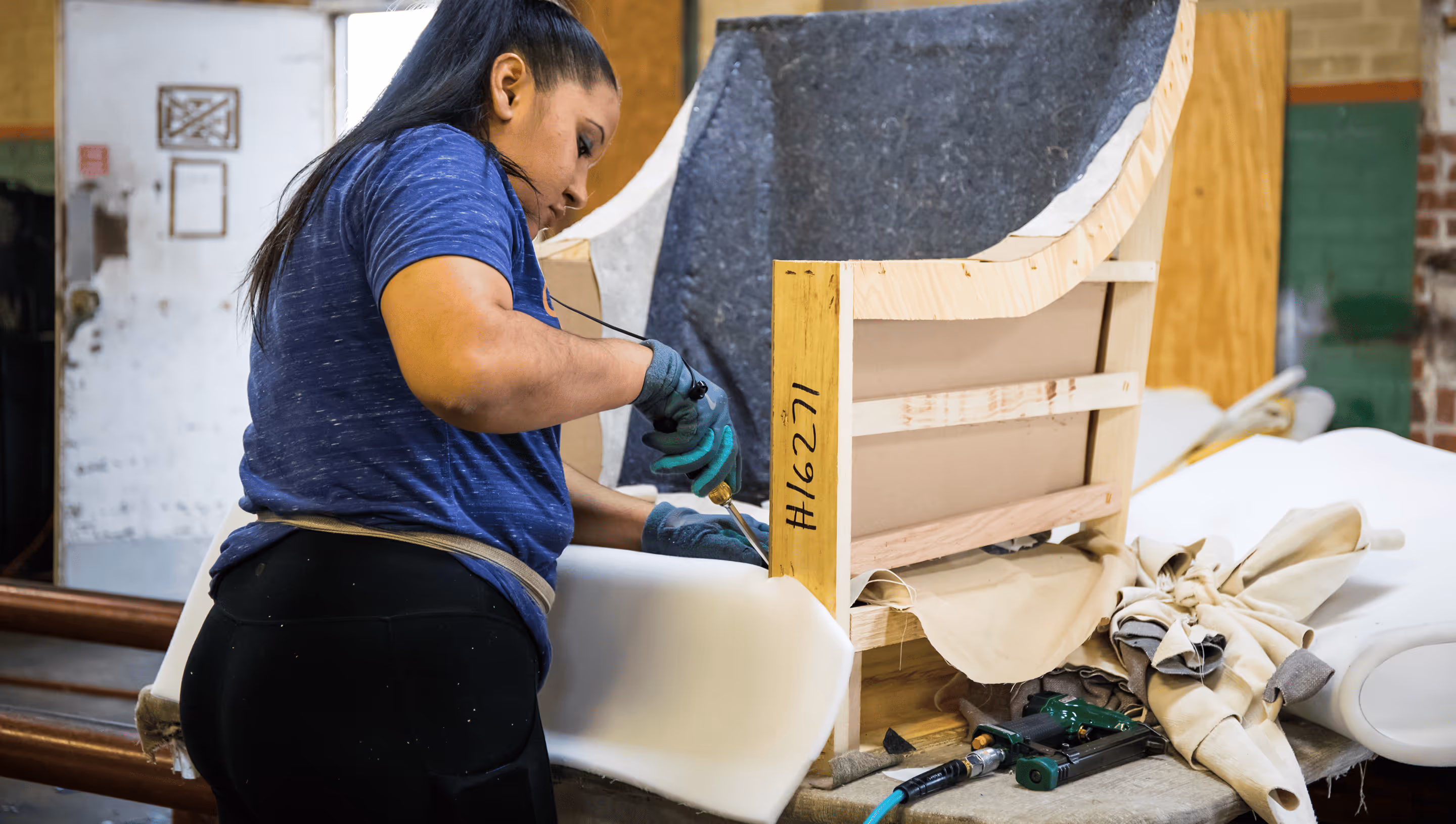 Expert artisan inspecting custom furniture framing in factory